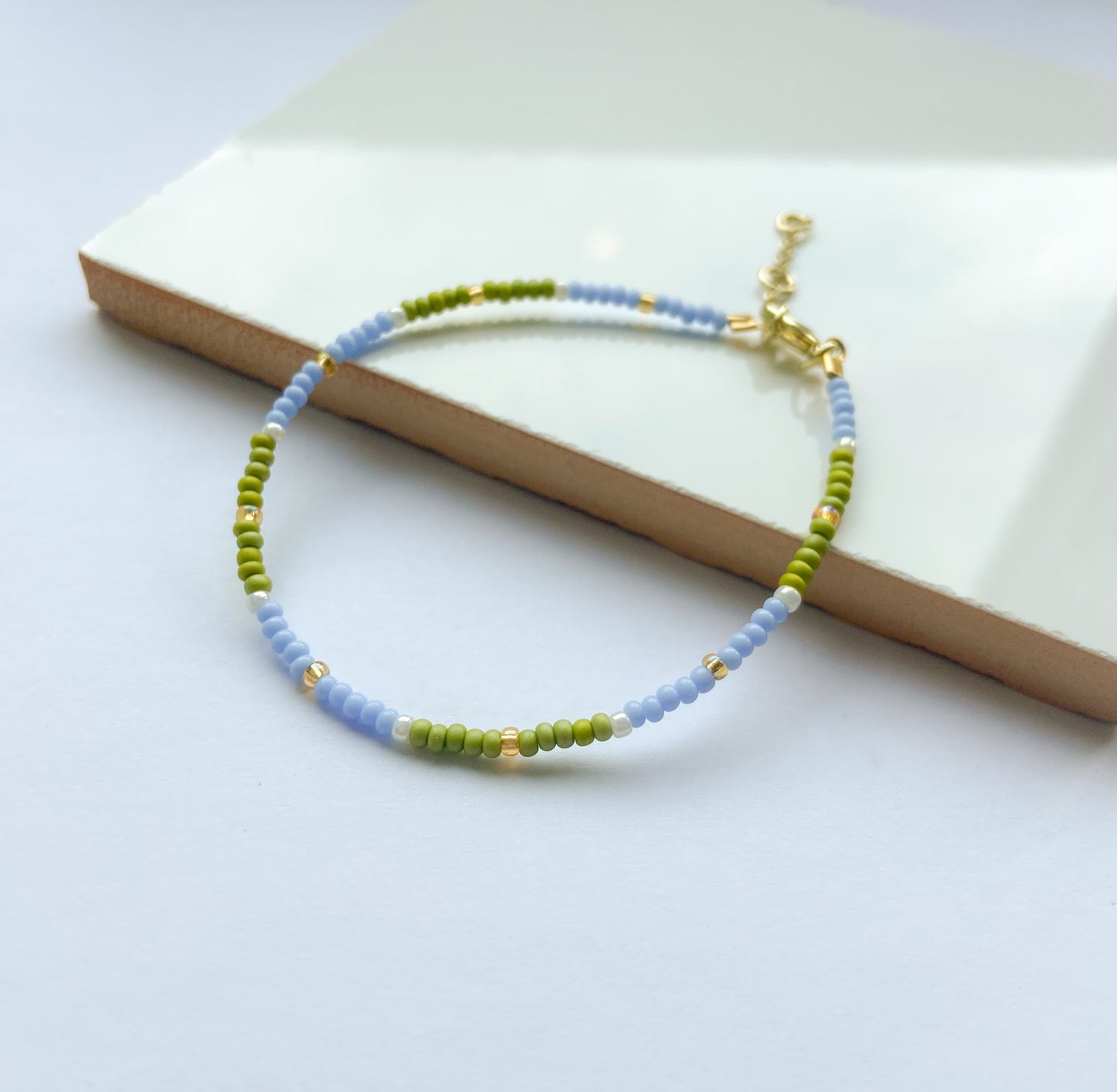 Dainty miyuki bead bracelet in green and blue with gold detail